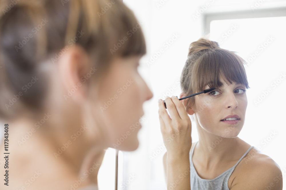 Beautiful young woman applying mascara Beautiful young woman applying mascara