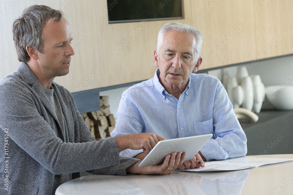 Senior man meeting with financial advisor at home Senior man meeting with financial advisor at home