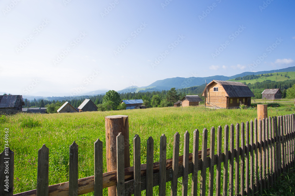 wooden houses on a grass hills