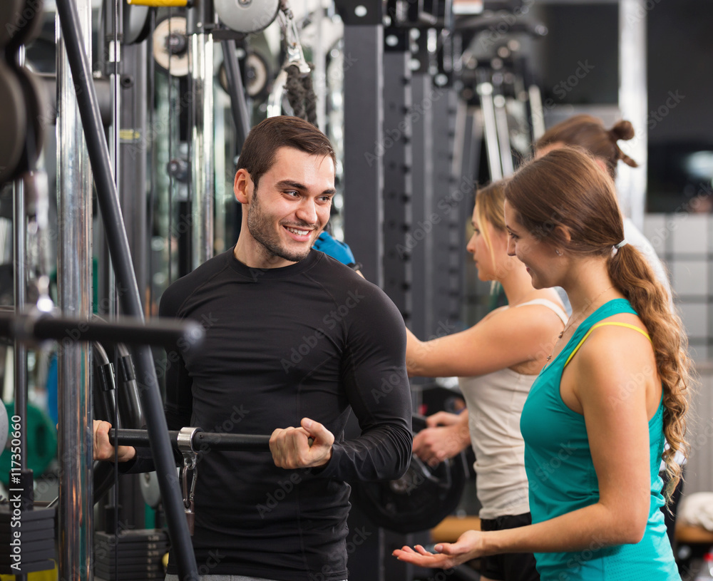 Fototapeta premium Active people having weightlifting training in club