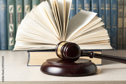 Tablou pe pânză Law concept - Book with wooden judges gavel on table in a courtroom or enforcement office