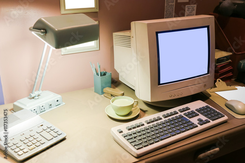 Retro office desk in dark room with simulator object.