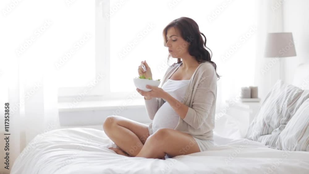 pregnant woman eating salad in bed at home 45 pregnant woman eating salad in bed at home 45