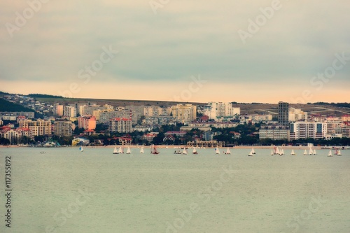 Sea resort town of Gelendzhik at sunset on Black sea coast. Retro card styling