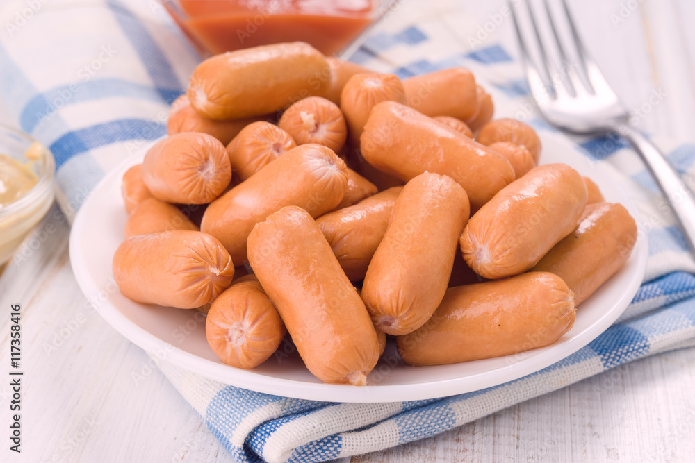 making near an overflowing plate of mini Frankfurters making near an overflowing plate of mini Frankfurters