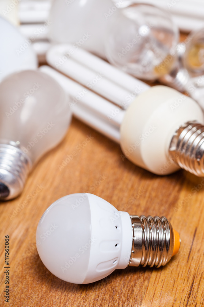 energy saving LED lamp and pile of old bulbs energy saving LED lamp and pile of old bulbs