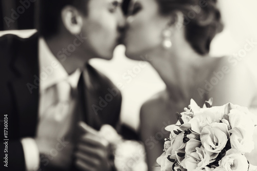 Wedding bouquet lies on the frontground of a black and white pic photo