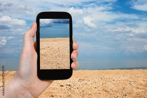 shelly and sand beach of Azov Sea on smartphone photo