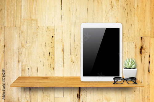 Digital tablet on bookshelf.