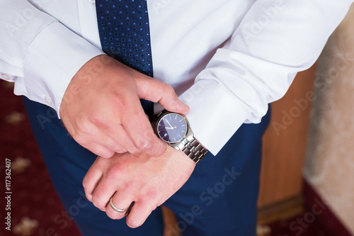 The man in the white shirt wears watches.