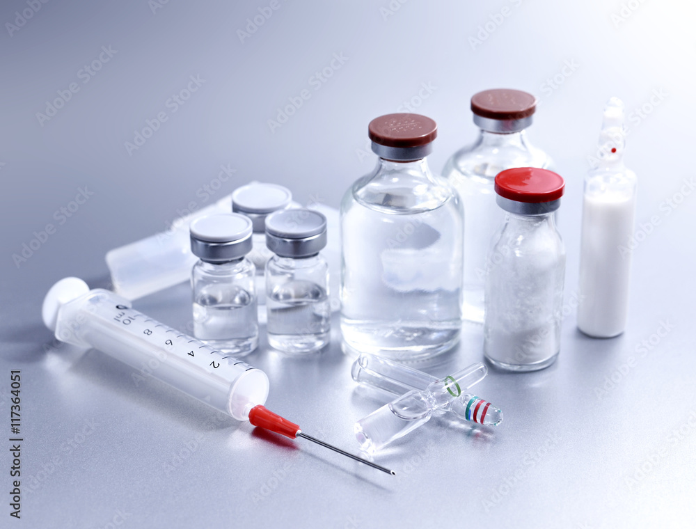 Vials and syringe, studio shot. Medical objects for vaccination. Vaccine drew up into a syringe. Vials and syringe, studio shot. Medical objects for vaccination. Vaccine drew up into a syringe.