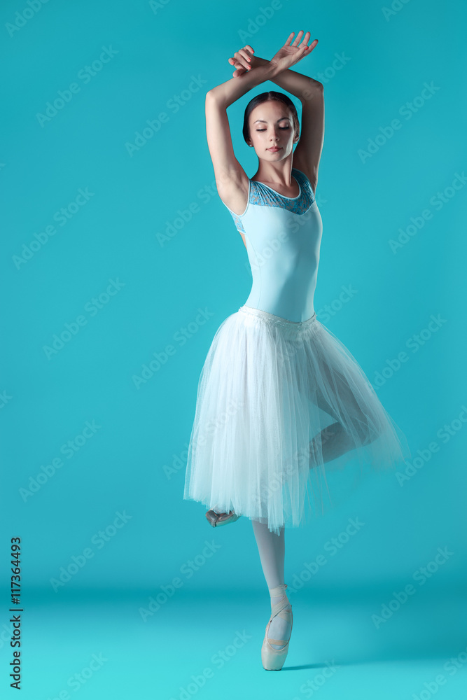 Ballerina in white dress posing on toes, studio background. Ballerina in white dress posing on toes, studio background.