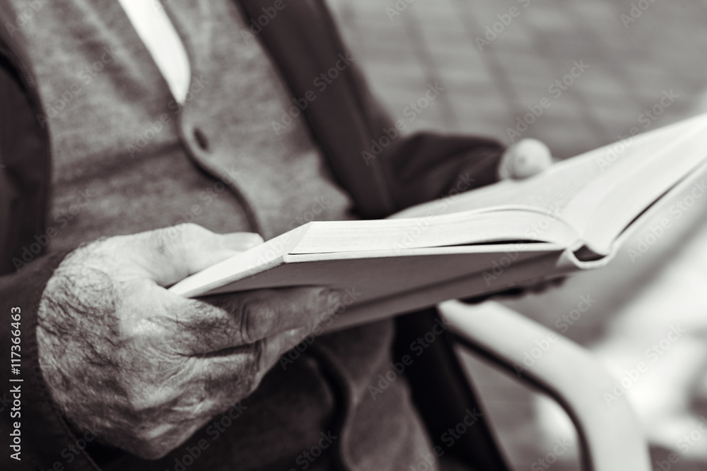 old man reading a book, in black and white