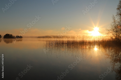 Sunrise on the lake with haze.