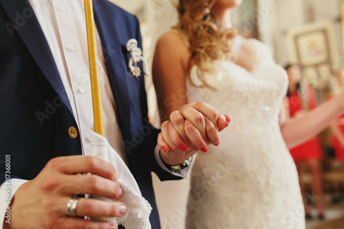 A closeup of newlyweds hands held tightly during an engagement c © IVASHstudio