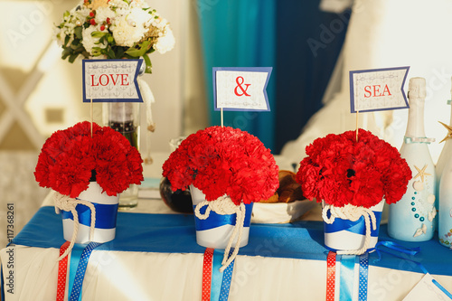 Flags with lettering 'Love & sea' stand in a bouquets of carnati photo