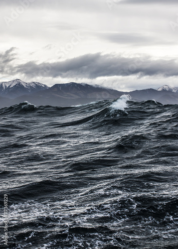 high storm wave on the background of rocks