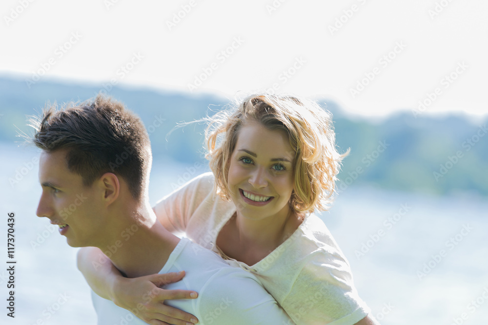 Obraz premium Man giving piggyback ride- carrying on the back his girlfriend