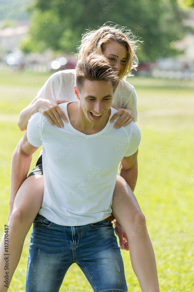 Man giving piggyback ride- carrying on the back his girlfriend