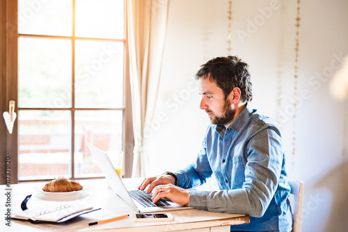 Man sitting at desk working from home on laptop