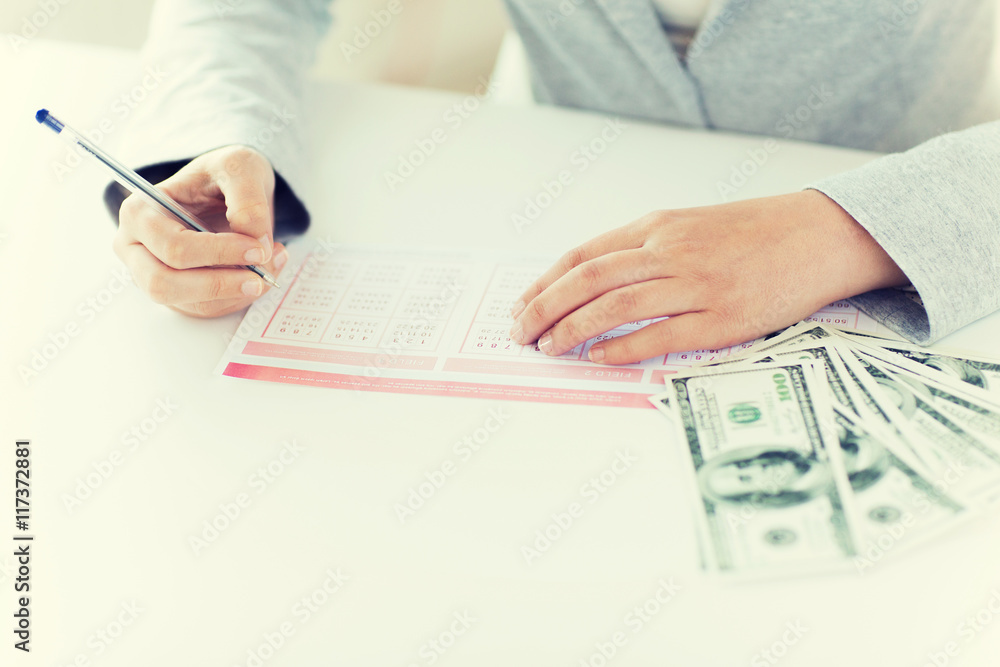 Fototapeta premium close up of hands with lottery ticket and money