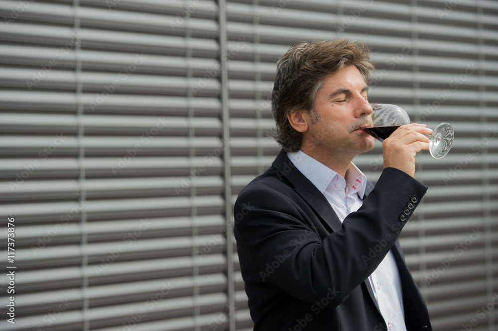 Portrait confidant vintner drinking red wine in winery Portrait confidant vintner drinking red wine in winery