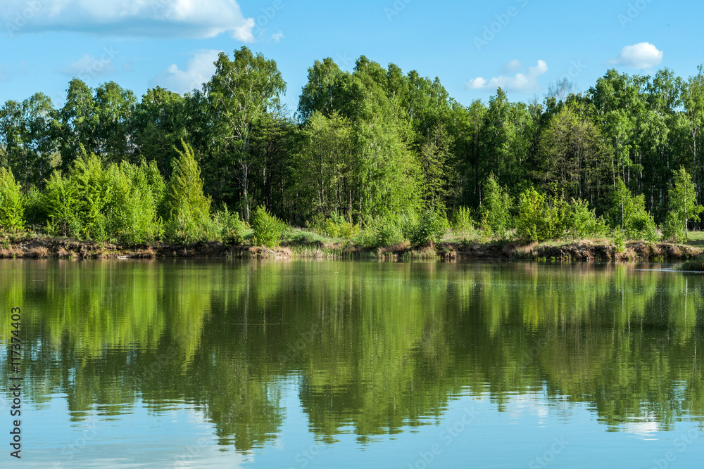 Beautiful lake landscape with sky and trees reflected in the water Beautiful lake landscape with sky and trees reflected in the water