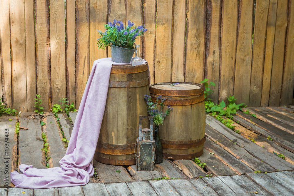 Fototapeta premium two barrels in the background of a wooden wall decorated with lavender and purple cloth