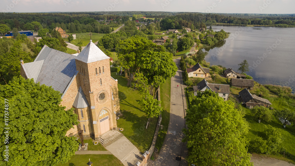 Naklejka premium AERIAL. Beautiful summer shot of Vepriai church and lake 