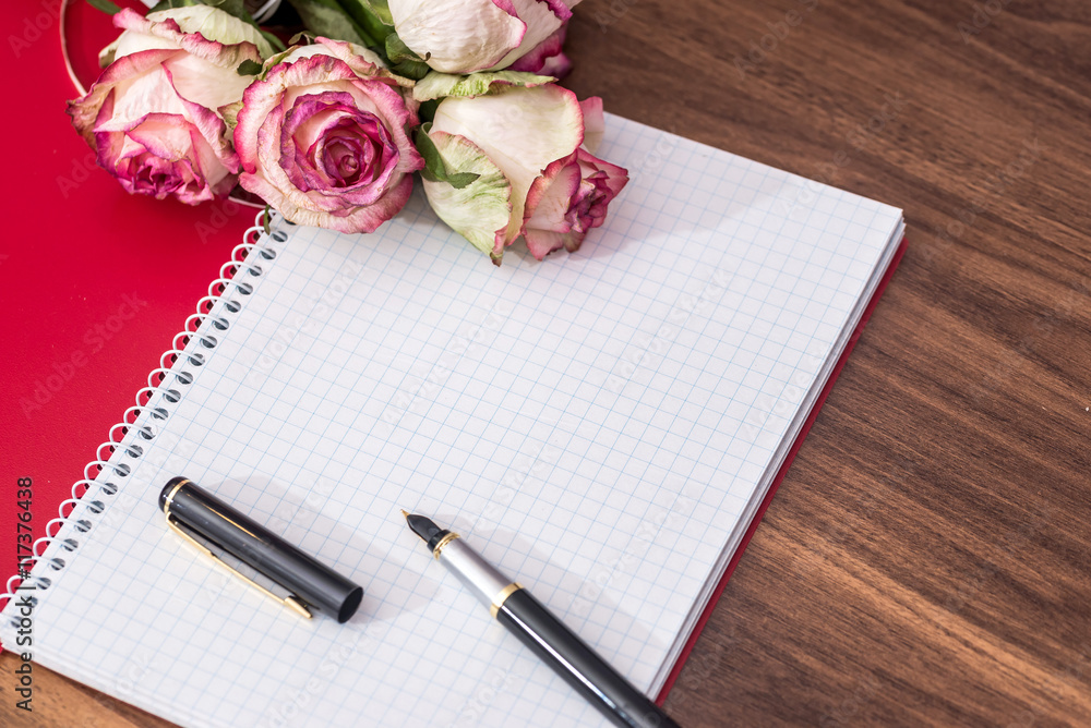 roses with empty note and pen roses with empty note and pen
