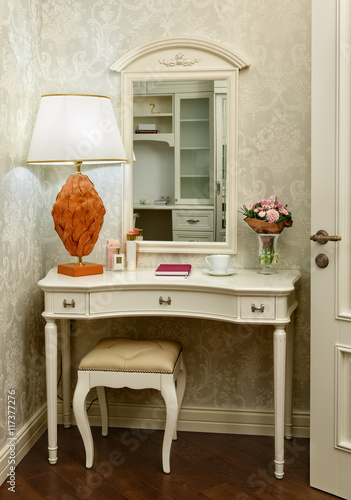 Photo Interior room with dressing table, stool and table lamp