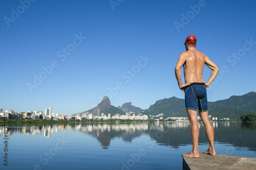 Athlete swimmer with swimming cap standing in front of the Rio de Janeiro skyline at Lagoa Rodrigo de Freitas lagoon