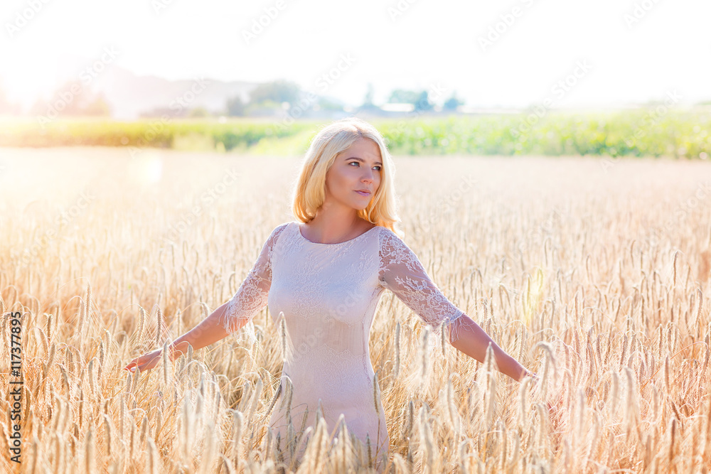Junge Frau im Kornfeld bei Sonnenuntergang Junge Frau im Kornfeld bei Sonnenuntergang