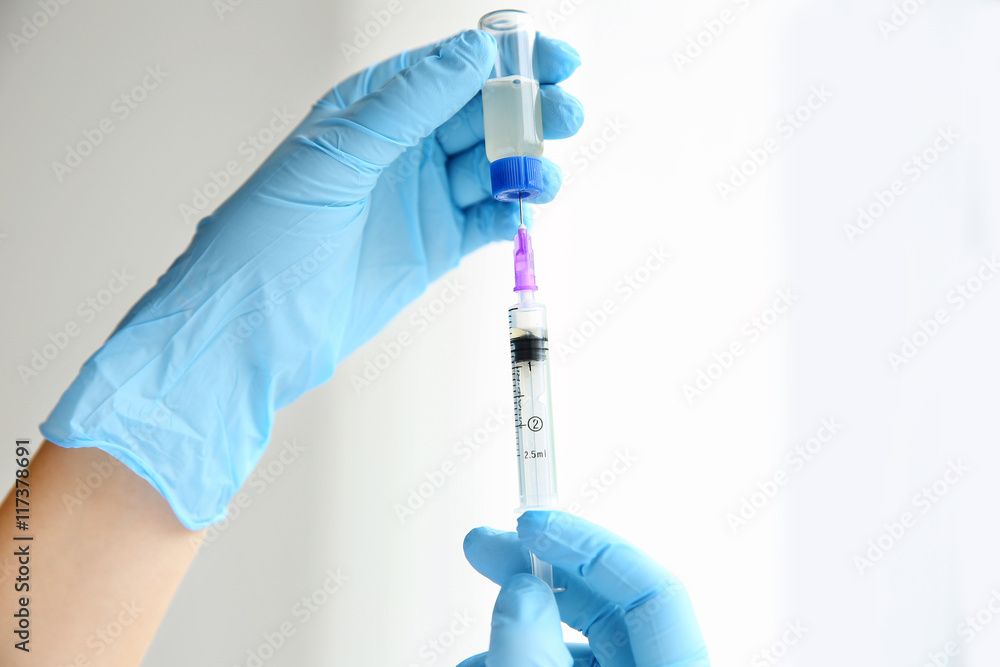 Hands in gloves with syringe Hands in gloves with syringe
