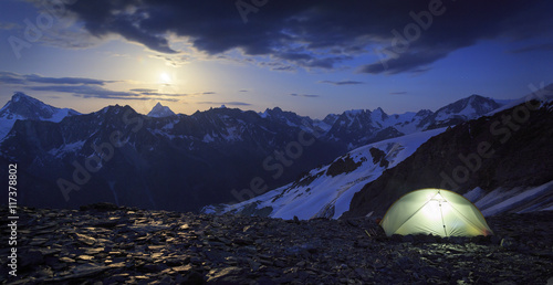 High altitude campesite with the moon rising above the Matterhorn in Wallis, Switzerland. Outdoor and adventure concept.