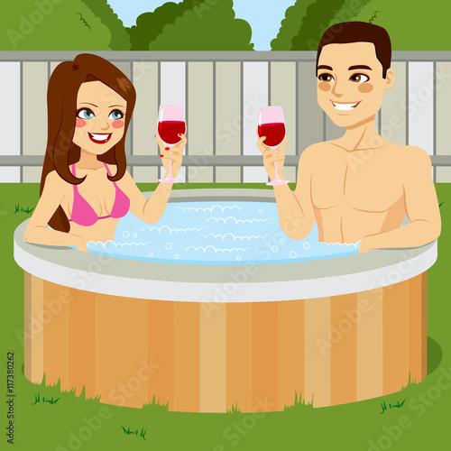 Young couple enjoying outdoor jacuzzi hot tub toasting with red wine