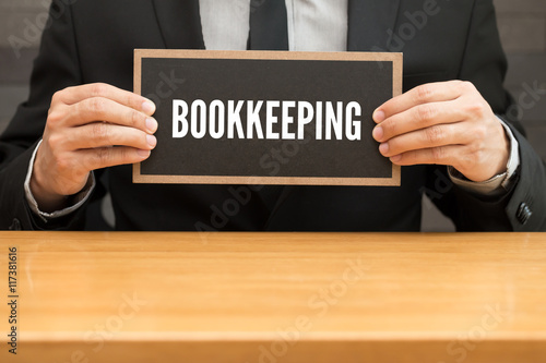 Bookkeeping. word writing on black banner and holding by busines