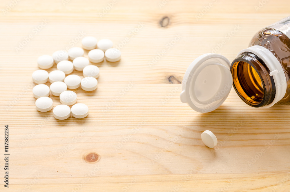 medicine tablets on wood background medicine tablets on wood background