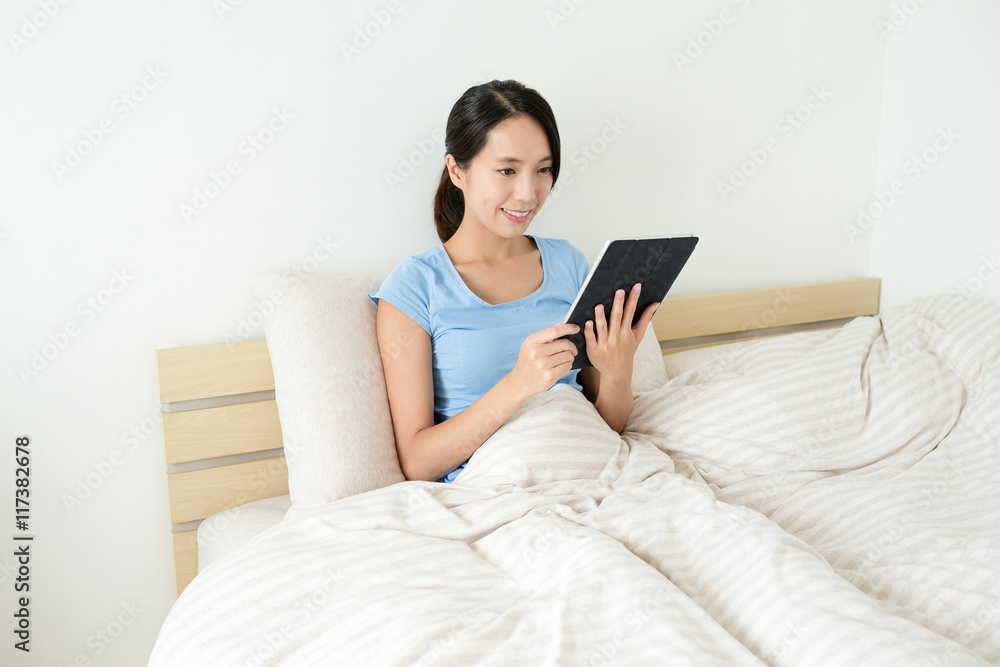 Woman using tablet on bed Woman using tablet on bed