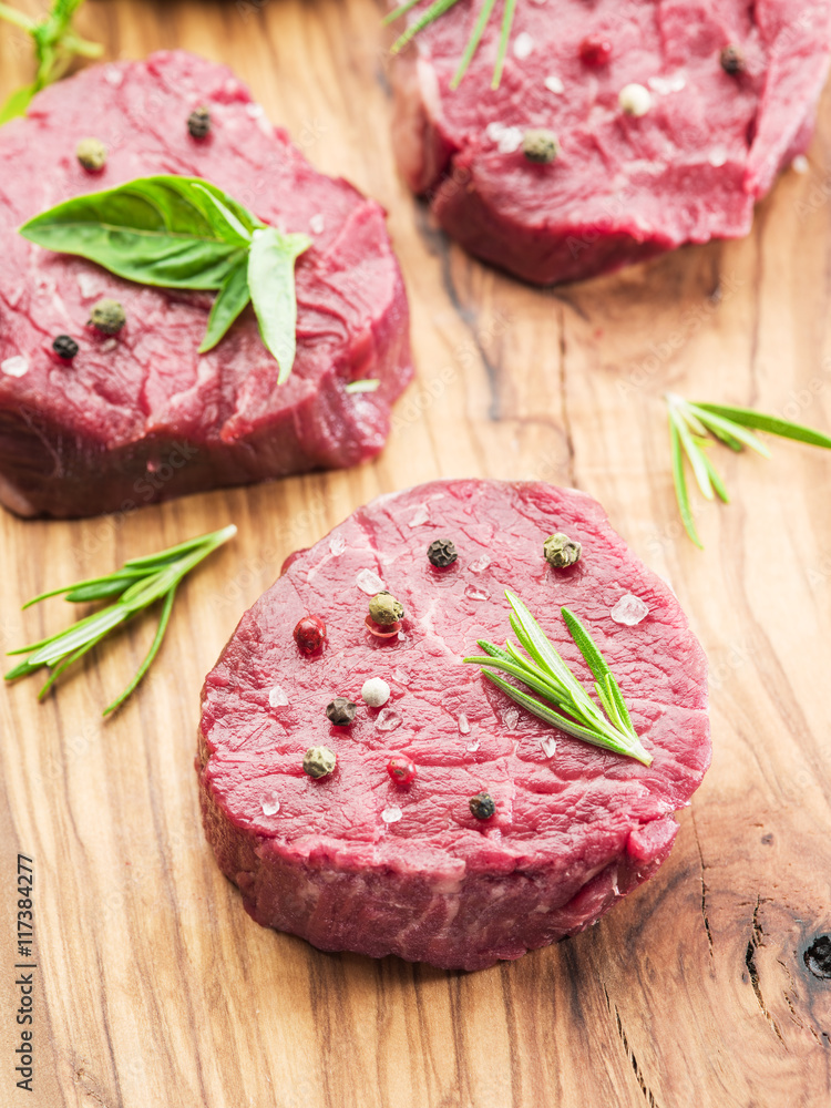 Pieces of beef tenderloin on the wooden cutting board.