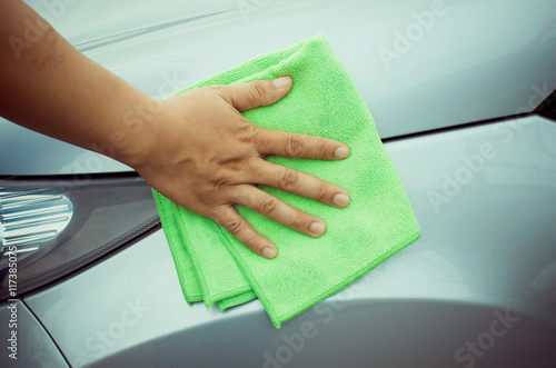 Fotografija Hand with  microfiber cloth cleaning car.
