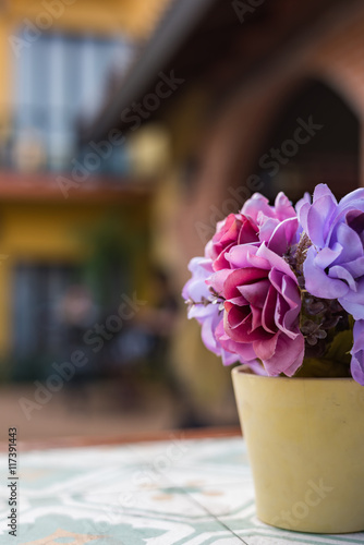 Artificial flower in pot on the table. Selective Focus.