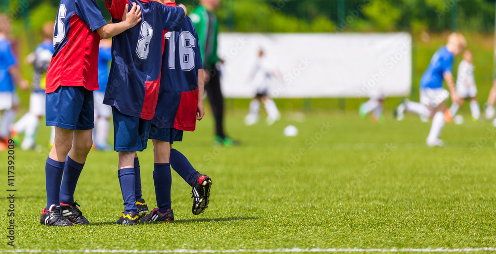 Young football players on the pitch. Grass sports field. Horizontal youth soccer picture. Young football players on the pitch. Grass sports field. Horizontal youth soccer picture.