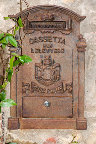 Old cast iron letterbox in the medieval town Lucignano in Tuscany, Italy. photo