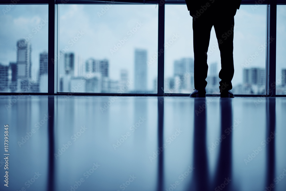 Cropped image of business person looking at big city through the window Cropped image of business person looking at big city through the window