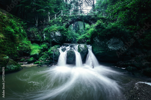 Wasserfall mit Brücke im Wald