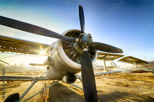 Canvas Print Old ruined biplane stands in the parking lot of an abandoned airfield