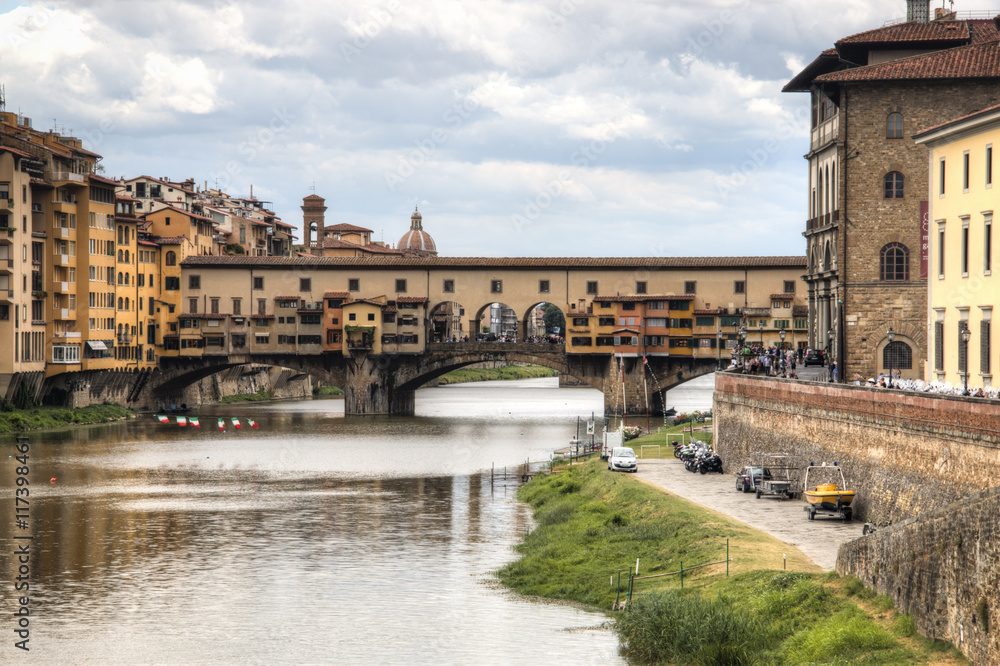 Several historical buildings and the Ponte Vecchio bridge next to the Arno river near the city of Florence, Italy
