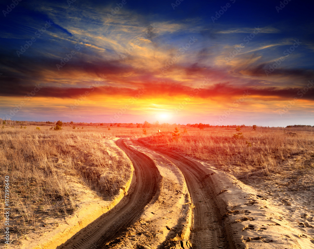 road in sands against sunset background