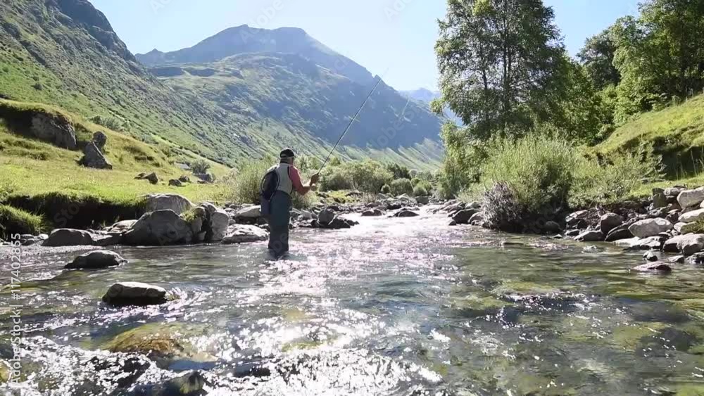 Fisherman fly-fishing in Pyrenees mountain river Fisherman fly-fishing in Pyrenees mountain river